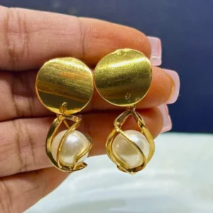 A pair of elegant, minimalist drop earrings with a single, lustrous pearl suspended from a thin gold or silver wire.