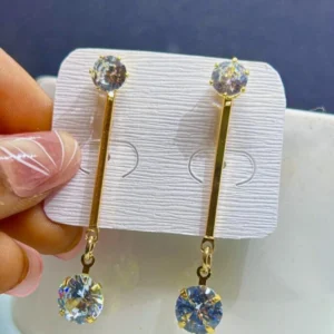 A pair of golden drop earrings with a long, thin, rectangular design and a subtle shimmer.