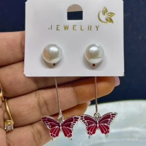 A pair of delicate drop earrings with a dangling butterfly charm with a shimmering finish.