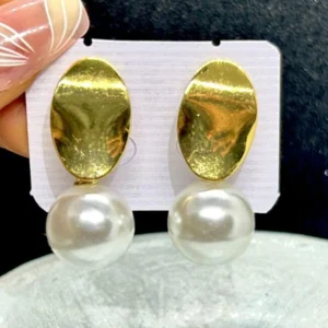 A pair of stylish drop earrings with a thin gold chain and a single, luminous pearl dangling at the bottom.