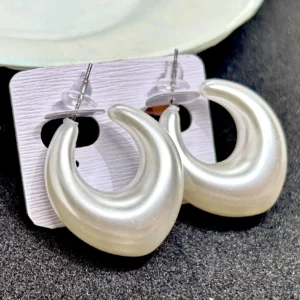 A pair of small, stylish stud earrings with a delicate C-shaped loop design.