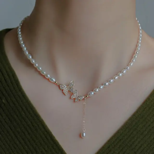 A delicate pendant with a small butterfly design with a lustrous pearl in the center.