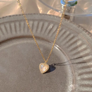 A minimalist, gold-plated heart pendant hanging from a simple chain.