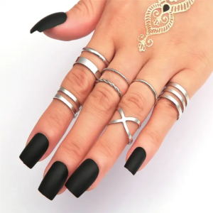 A collection of eight assorted silver rings, with various designs including simple bands, rings with small rhinestones, and twisted patterns.