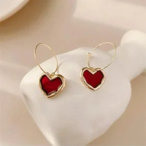 A pair of vibrant drop earrings with a small, red, heart-shaped charm.