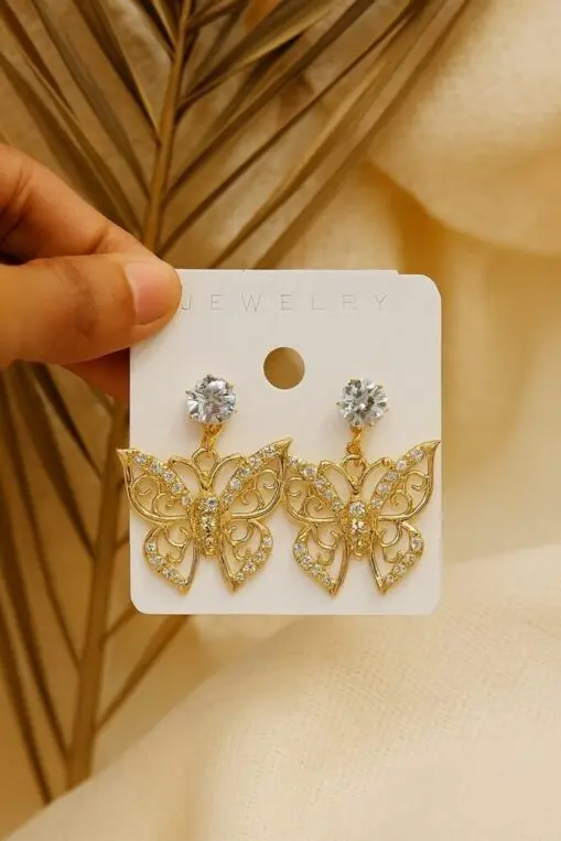 Gold butterfly earrings with intricate design on display