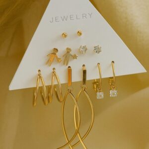 Stylish gold earrings variety on display card with neutral backdrop