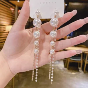 Elegant dangling pearl earrings on display in a cozy setting