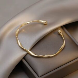 Elegant gold bracelet on a satin and gift box background