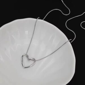 Elegant silver heart necklace on a white ceramic dish