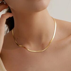 Elegant gold necklace on woman's neck enhancing style.